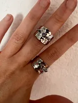 Anillo plateado de cobre con forma irregular y piedras de colores.