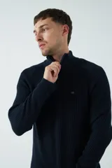 Sweater azul marino de punto con cuello alto y cierre de cremallera parcial. Tiene mangas largas, corte regular y logo bordado en el pecho.