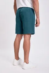 Bermuda casual de hombre color verde azulado, con cintura ajustable mediante cordón y bolsillos laterales.