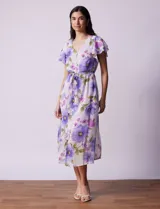 Vestido midi de gasa estampada con flores violetas y verdes, escote en V, abertura central con botones, cintura con lazo de ajuste y forro interno a tono.