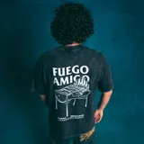 Remera negra de corte oversize con efecto gastado y estampa pequeña en el pecho de una parrilla con fuego y el texto "Kaboa Industries".
