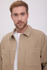 Sobrecamisa color beige de manga larga con cierre de botones, cuello camisero y bolsillos de parche en el pecho.