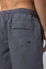 Short de baño gris con cintura elastizada y cordón ajustable. Tiene bolsillos laterales y logo de la marca en la pierna derecha.