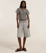 Blusa femenina de punto con cuello polo, mangas cortas y estampado de rayas horizontales en tonos naranja, marrón, blanco y verde.