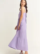 Vestido largo color beige con volados en diferentes tamaños y escote cuadrado con lazos en la espalda.
