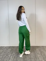 Pantalón babucha verde oliva, estilo cargo, con cintura elástica, bolsillos laterales con solapa y puños elásticos.