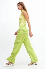 Pantalón cargo verde lima de satén, tiro medio y corte holgado con múltiples bolsillos.