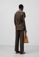Pantalón marrón de lino para mujer, con cierre de botón, bolsillos laterales y raya de plancha en delantero y espalda.