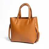 Cartera mediana color habano, de símil cuero, con doble asa corta y correa larga regulable y desmontable. Tiene acceso abierto, dos compartimentos y un bolsillo interno con cierre.