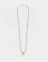 Collar largo con cadena dorada, detalles de piedras blancas irregulares y dije de corazón de nácar.