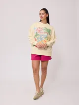Sweater color crema con estampado frontal de motivos playeros y bordado. Confeccionado en 60% algodón y 40% poliéster.