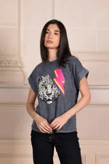 Remera gris con efecto gastado, cuello redondo y mangas cortas con dobladillo. Estampado frontal de un rostro de leopardo en blanco y negro con un rayo rosa y amarillo.