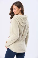 Campera de sherpa suave color beige, con capucha, cierre frontal con detalles en cuero y bolsillos laterales.