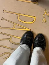 Championes deportivos de cuero y gamuza color dorado metalizado y marrón. Suela de caucho color crema con línea roja. Cordones color crema.