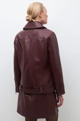 Chaqueta biker de cuero sintético color bordó, con cierre asimétrico y cuello con solapas.