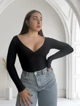 Body negro de mangas largas con escote en V cruzado.