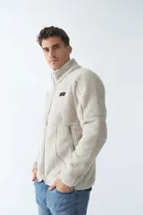 Campera de sherpa verde militar con cierre frontal y bolsillos laterales con cierre.