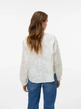 Camisa blanca de manga larga con cuello en V, cierre frontal con botones, puños abotonados y bordado floral.