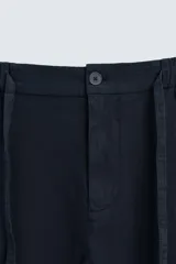 Pantalón azul marino de corte recto, confeccionado en tejido de algodón y lino. Tiene cintura elástica ajustable con cordón, bolsillos delanteros y traseros de vivo.