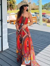 Vestido largo strapless con estampado étnico en tonos naranja, azul, negro y blanco. Incluye cinturón plateado con detalles de turquesa.