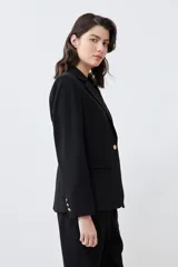 Blazer negro de corte clásico con solapas de muesca, cierre frontal con un botón y bolsillos con solapa.
