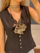 Accesorio de cuero color peltre con forma de flor. Puede usarse como colgante, faja o gargantilla.