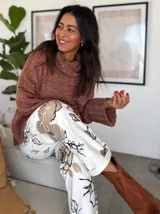 Sweater de punto color ladrillo, con cuello alto y mangas largas con puños acampanados. Decorado con perlas sintéticas en el frente y en los puños.