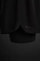 Shorts de running negros con malla interior, cintura elástica ajustable con cordón, bolsillo trasero con cierre, bolsillo multifunción en la malla interior, perneras perforadas, bajo termofijado, aberturas laterales y logo estampado.