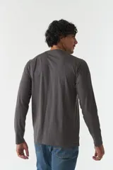 Remera de manga larga gris con cuello redondo y estampado con logo y texto en el frente.