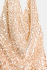 Vestido corto de cuello halter y escote fluido, color dorado, con lentejuelas y forro interior. Cierre lateral con cremallera oculta en costura.