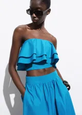 Top strapless celeste con volados y cierre de cremallera en la parte posterior.