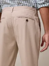 Pantalón de vestir color beige, de corte recto, con bolsillos laterales y traseros. Se ajusta a la cintura con cordón.