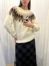 Sweater tejido a mano en Uruguay con lana merino color crudo, con diseño geométrico en tonos marrón y beige en la parte superior.