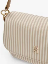 Cartera de hombro Tommy Hilfiger con rayas verticales beige y blancas, logo dorado en el frente, correa de mano marrón y correa bandolera ancha color beige.