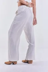 Pantalón de lino color beige, de corte recto y tiro alto, con cierre de botón y cremallera.