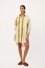 Camisa tipo vestido con cuello camisero, manga larga y estampado a rayas verticales en tonos verde y blanco.