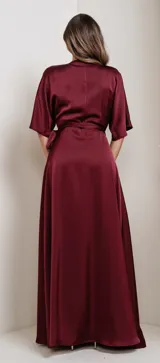 Vestido largo azul de satén, con escote en V cruzado, mangas kimono cortas y lazo en la cintura.