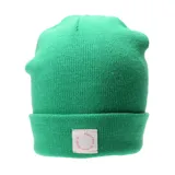Gorro de tejido de punto color verde brillante, estilo beanie con doblez en el borde. Incluye una pequeña etiqueta cuadrada de tela blanca con texto circular en color rosado que dice "Expect only all good things".