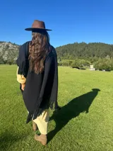 Ruana color beige confeccionada en lana merino con flecos en el borde inferior.