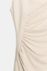 Vestido midi color blanco hueso, sin mangas, con cuello alto y detalle de drapeado fruncido en el lateral izquierdo del torso.