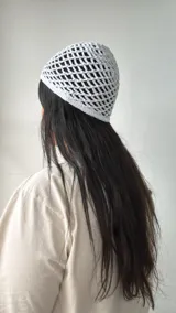 Gorro blanco de crochet con diseño calado.