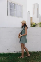 Vestido corto blanco de lino, musculosa con volado en cuello y acceso frontal cruzado. Abotonadura forrada en lino.