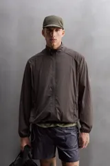 Cazadora relaxed fit confeccionada en tejido técnico ligero color marrón. Cuello subido, manga larga acabada en puño con elástico, bolsillos frontales en cadera con cierre de cremallera oculta en costura y cierre frontal con cremallera.