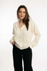 Blusa azul marino de manga larga en tela tipo seda, con escote en V con volado en todo el escote.