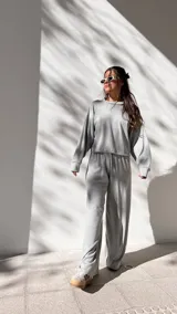 Conjunto deportivo gris de algodón waffle, compuesto por un buzo de corte cropped y un pantalón de corte ancho con cintura elastizada.