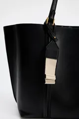 Bolso negro tipo shopper con asa de hombro, detalle de colgador y bolsillo interior maxi. Cierre mediante imán.