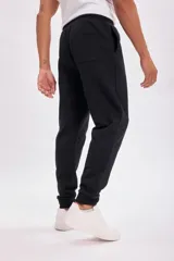 Pantalón deportivo tipo jogger color negro con tejido interior afelpado, corte clásico y cintura elástica.