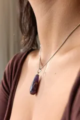 Collar dorado con cadena fina y dije colgante en forma de lágrima de piedra natural azul con vetas blancas.