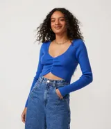 Blusa cropped azul de punto acanalado con escote en V, mangas largas y fruncido frontal.