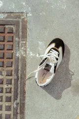 Zapatillas deportivas urbanas de cuero color blanco, con puntera y talón en cuero negro y detalles en color tostado.